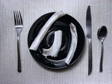 Photo of bones on black plate with dinner setting