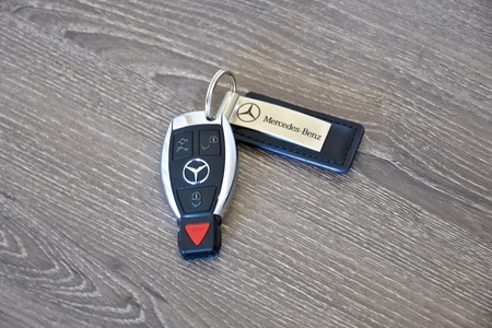 MARYLAND, USA - APRIL 10, 2016: A Mercedes-Benz key fob laying on a wood surface. Mercedes-Benz is a luxury car manufacturer and dealer.のeditorial素材