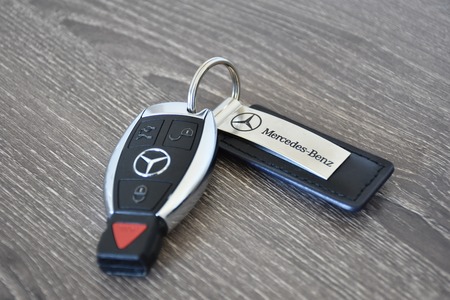 MARYLAND, USA - APRIL 10, 2016: A Mercedes-Benz key fob laying on a wood surface. Mercedes-Benz is a luxury car manufacturer and dealer.のeditorial素材