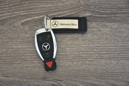MARYLAND, USA - APRIL 10, 2016: A Mercedes-Benz key fob laying on a wood surface. Mercedes-Benz is a luxury car manufacturer and dealer.のeditorial素材