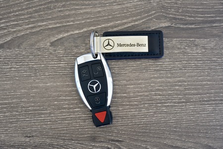MARYLAND, USA - APRIL 10, 2016: A Mercedes-Benz key fob laying on a wood surface. Mercedes-Benz is a luxury car manufacturer and dealer.のeditorial素材