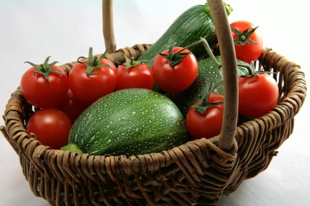 Basket of tomatoes and zucchinis in close-upの写真素材