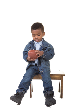 A cute boy with a football isolated on whiteの写真素材