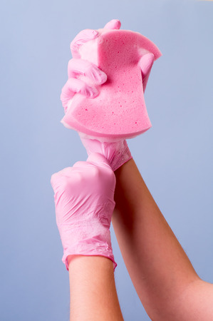 Women's hands wearing pink latex gloves for cleaningの写真素材