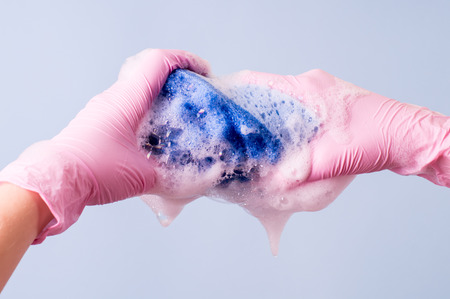 Women's hands wearing pink latex gloves for cleaningの写真素材