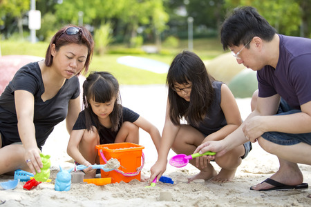 Young Asian family playing sand in parkの写真素材