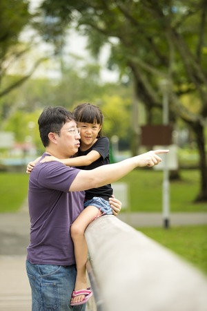 Young Asian father and daughter bonding in parkの写真素材