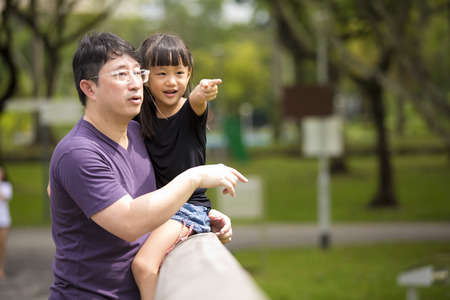 Asian father and daughter having fun in the parkの写真素材