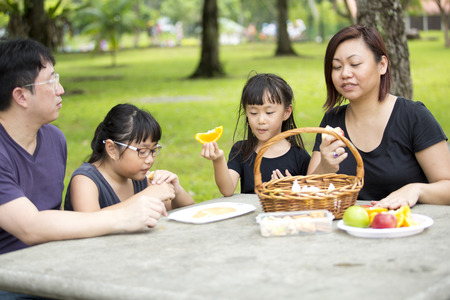 Young Asian family having picnic in parkの写真素材