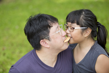 Young Asian father and daughter bonding in parkの写真素材