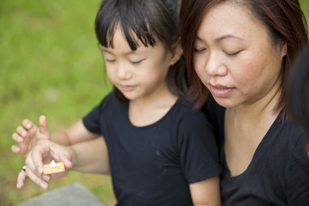 Young Asian mother and daughter bonding in park picnic