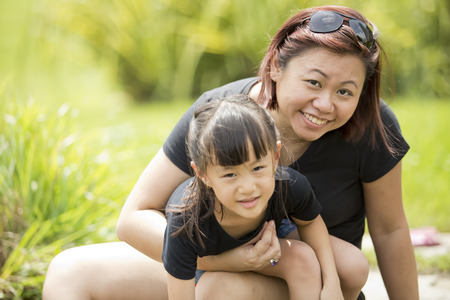 Young Asian mother and daughter having fun in riverの写真素材