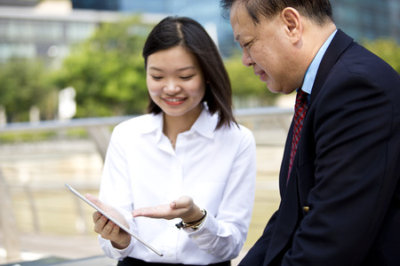 Asian businessman and young female executive using tabletの写真素材
