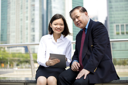 Asian businessman and young female executive looking at tabletの写真素材