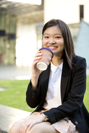 Young Asian female executive drinking coffeeの写真素材
