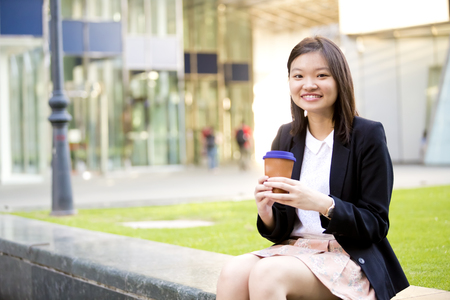 Young Asian female executive drinking coffeeの写真素材