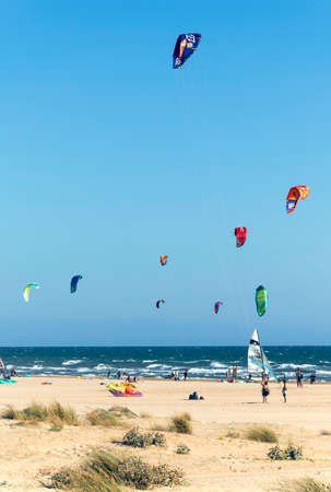 HUELVA, SPAIN, AUGUST 12, 2020 Punta UmbrÃ­a beach. Crowd of people practicing kitesurfing on the beach.のeditorial素材