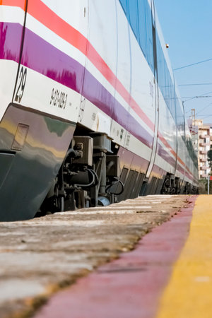 High speed train parked on the track awaiting its departure seen from a low plane at the platform