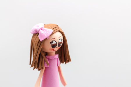 toy girl in a pink dress on a white background with copy spaceの写真素材