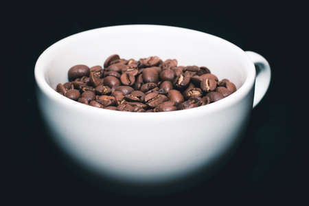 white coffee cup with coffee beans insideの写真素材
