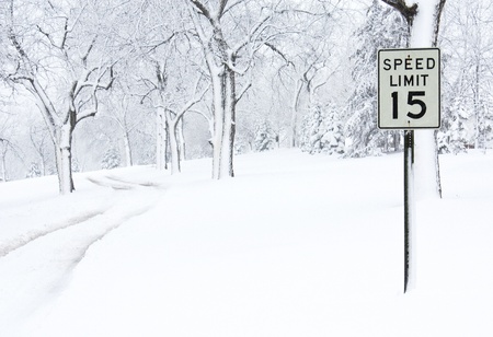 A speed limit sign on a snow covered road