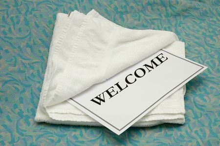 Welcome Towel on Bed at a Budget Hotelの写真素材