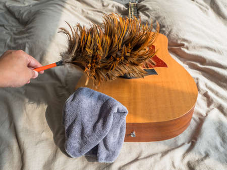 cleaning cloth and feather duster on guitarの写真素材
