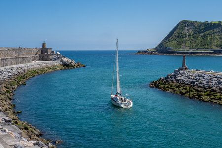 port entry and exit with a sailboatの写真素材