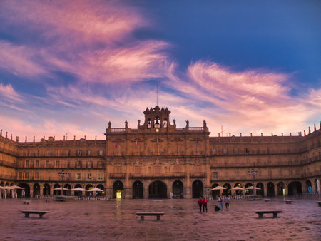 Twilight over Plaza Mayor of Salamanca: A striking view of the Plaza Mayor in Salamanca at twilight, framed by an archway with a lamppost hanging from it.の写真素材