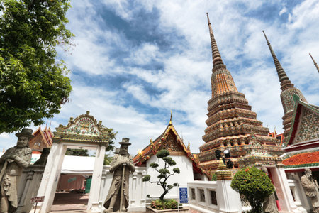 Guarding statues and chedi at Wat Pho - Ornate chedi and guardian statues with a Western influence, a blend of cultures at the famous Wat Pho temple in Bangkok.の写真素材