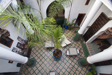 Interior patio in Moroccan riad - A high-angle shot of a beautiful interior patio with palm trees in...