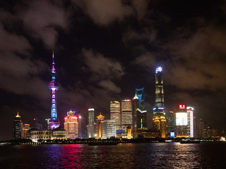 Shanghai Skyline at Night from the River - A captivating wide shot of the vibrant Shanghai Pudong...