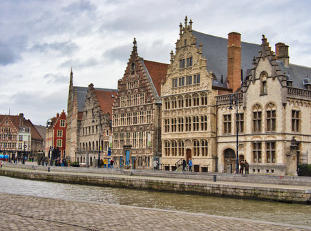 Guild Houses on the Leie River in Ghent - The historic Graslei and Korenlei guild houses line the Leie River, showcasing medieval Flemish architecture under a cloudy sky.の写真素材