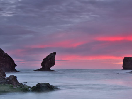 Vibrant Twilight Sky over Coastal Sea Stacks - Spectacular long exposure capturing a striking purple...