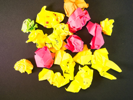 Crumpled Colorful Paper Pile - Heap of brightly colored, crumpled papers, including yellow, pink,...