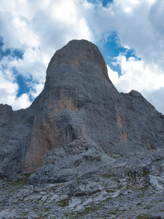 Imposing Naranjo de Bulnes Peak at Sunrise or Sunset - Majestic, vertical limestone wall of Picu Urriellu in Picos de Europa National Park, Spain, under a dramatic blue sky.の写真素材