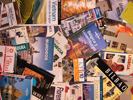 Jumble of International Travel Guide Books - High-angle flat lay of various colorful, scattered travel guides for European and Asian cities, symbolizing planning and adventure.の写真素材