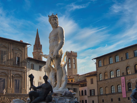 Neptune Fountain in Florence with Historic Towers - The colossal marble statue of Neptune and surrounding figures set in Piazza della Signoria, with Palazzo Vecchio tower in the background.の写真素材