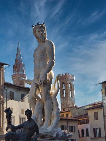 Neptune Fountain in Florence with Historic Towers - The colossal marble statue of Neptune and surrounding figures set in Piazza della Signoria, with Palazzo Vecchio tower in the background.の写真素材