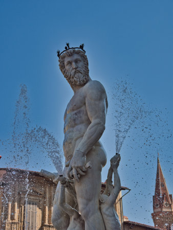 Neptune Fountain in Florence with Historic Towers - The colossal marble statue of Neptune and surrounding figures set in Piazza della Signoria, with Palazzo Vecchio tower in the background.の写真素材