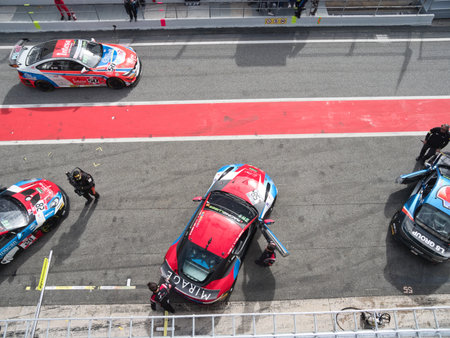 Pit Crew Working on Race Car Overhead - High-angle view of the pit crew and mechanics making...