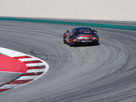 Race Car Cornering on Racetrack Curb - Rear view of a black and red GT race car taking a sharp...