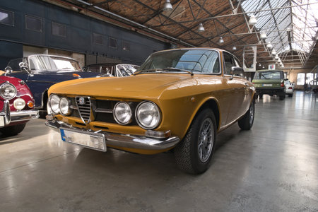 Vintage Yellow Italian Coupe in Showroom - Front view of a classic yellow Italian sports coupe with...