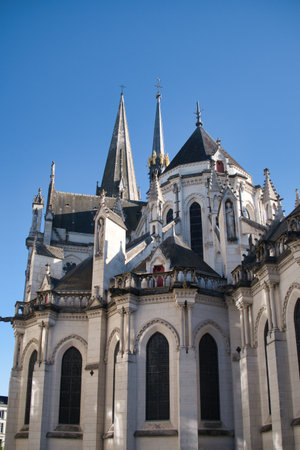 Gothic Cathedral Spiers and Apse Detail - Ornate Gothic cathedral exterior detail showing multiple stone spiers, pinnacles, and intricate tracery against a stark, clear blue sky.の写真素材