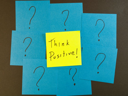 Think Positive! Among Question Marks - Yellow sticky note with 'Think Positive!' surrounded by blue...