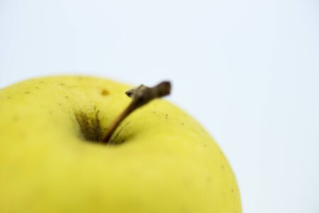 Yellow apple on white reflected backgroundの写真素材