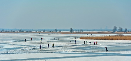 People skating on a frozen lake in winterの写真素材
