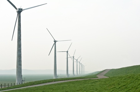 Wind turbines along a dam in springの写真素材