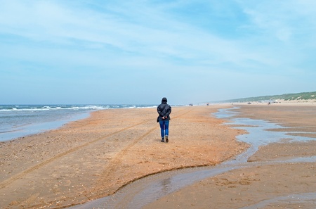 Woman walking on a beach in springの写真素材