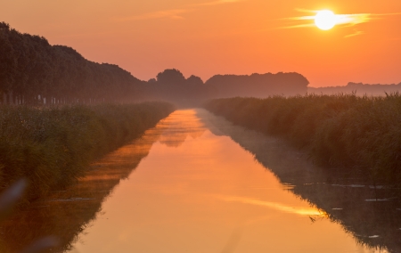 Sunrise over a canal in summerの写真素材